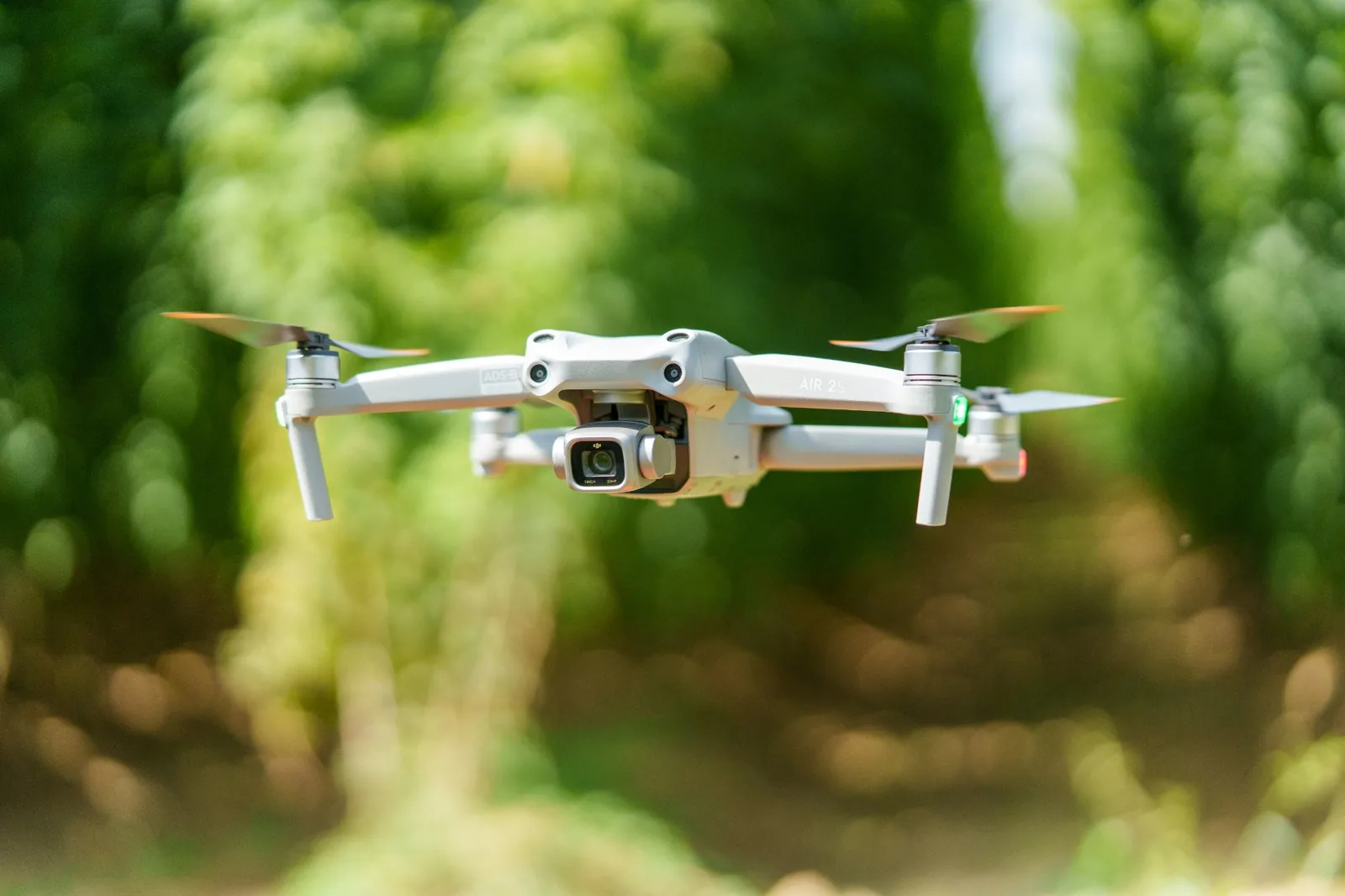 Camera drone in flight against a soft green background